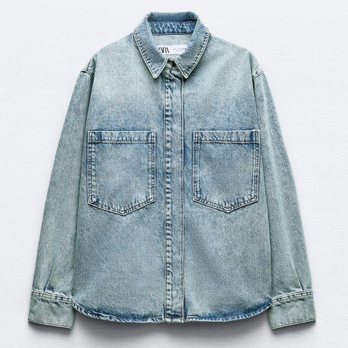 Light blue denim shirt on a white background