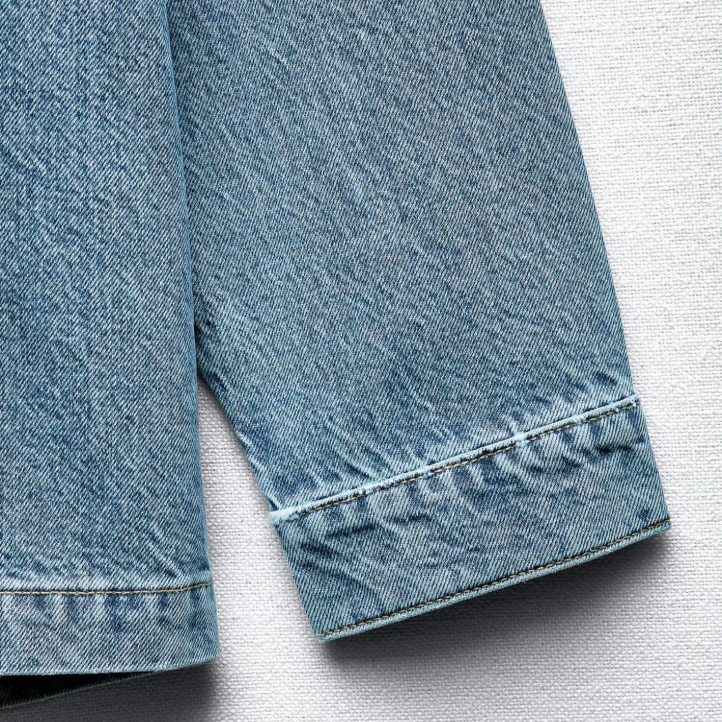 Close-up of a blue denim jacket on a light gray background