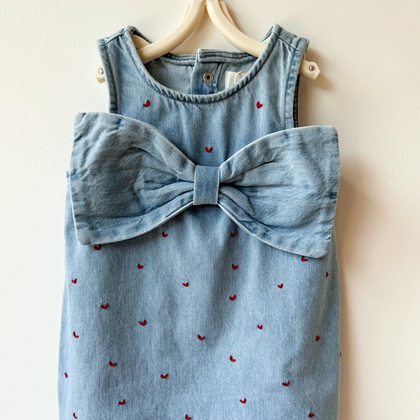 Blue denim dress with a large bow on a beige background