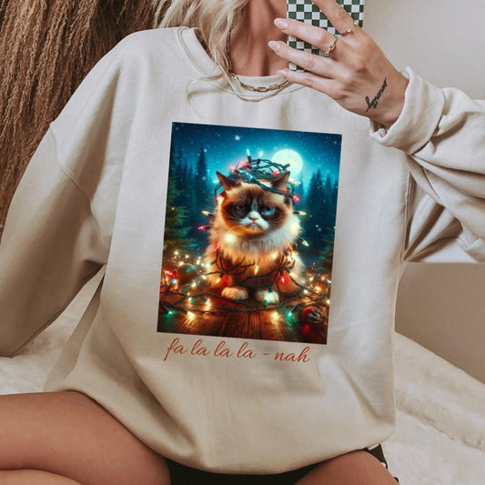 Person wearing a white sweatshirt with a Christmas-themed cat graphic and text.