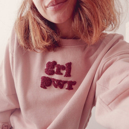 Person wearing a pink sweatshirt with 'Girl Power' text.