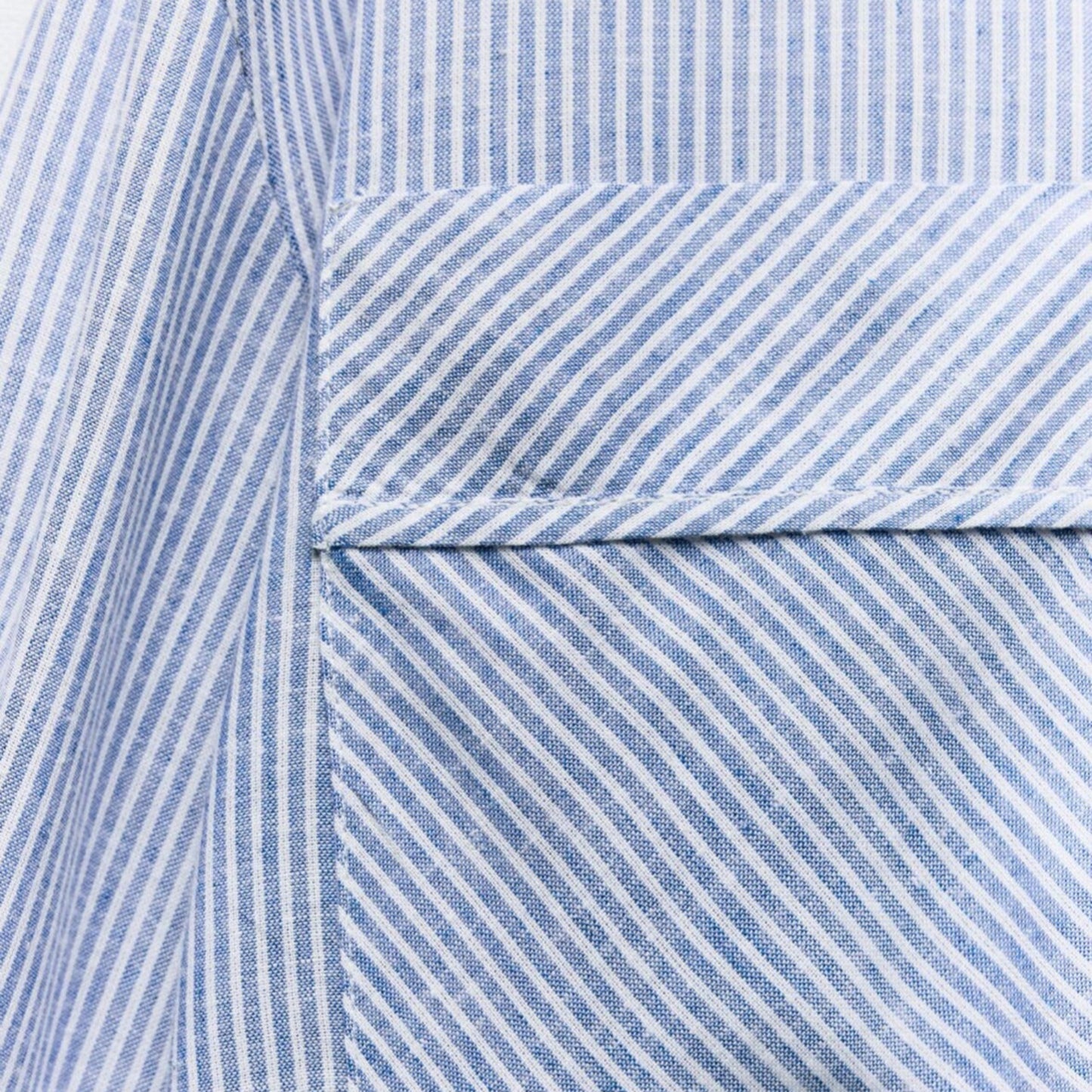 Close-up of a blue and white striped fabric with a pocket detail