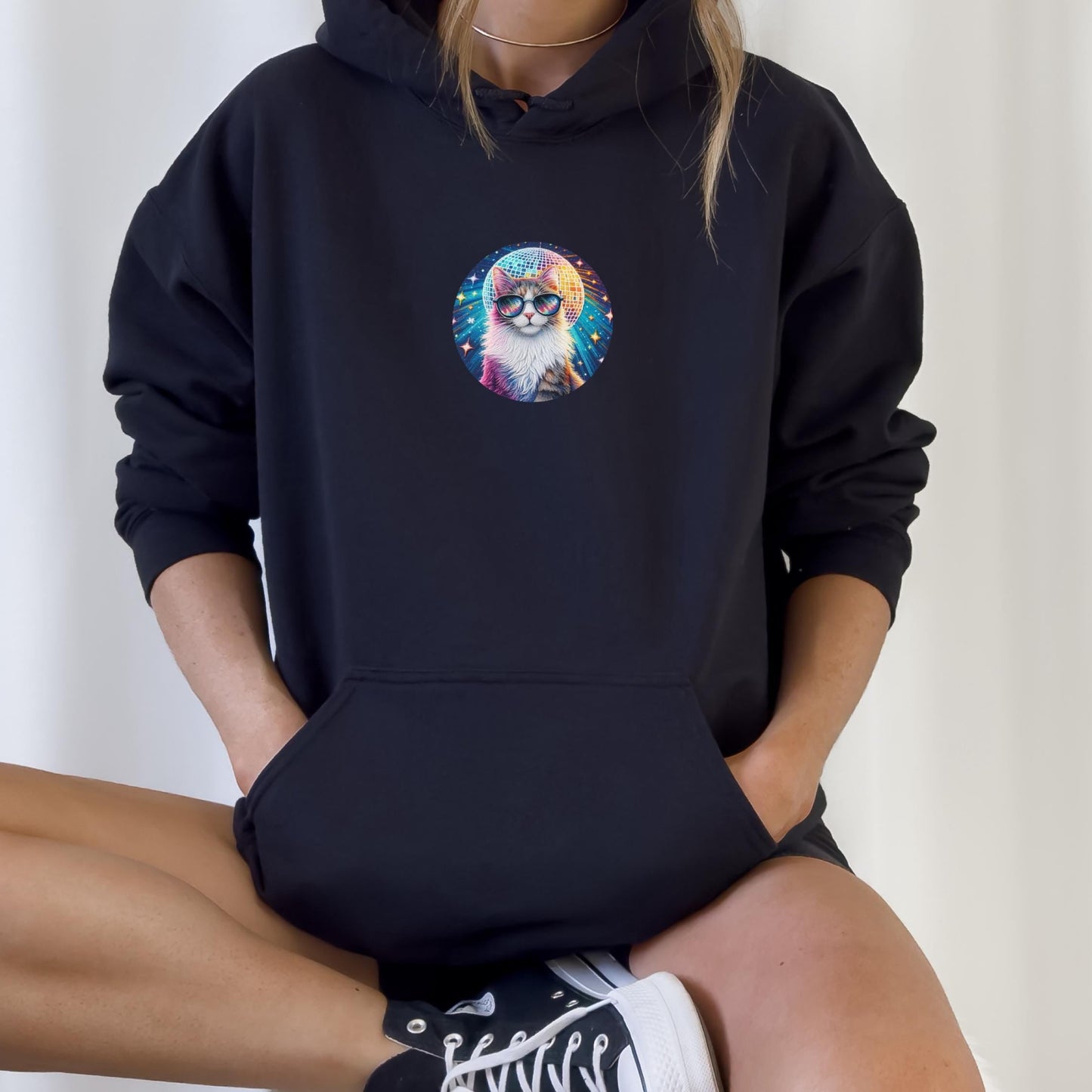 Person wearing a black hoodie with a colorful cat graphic design on a white background