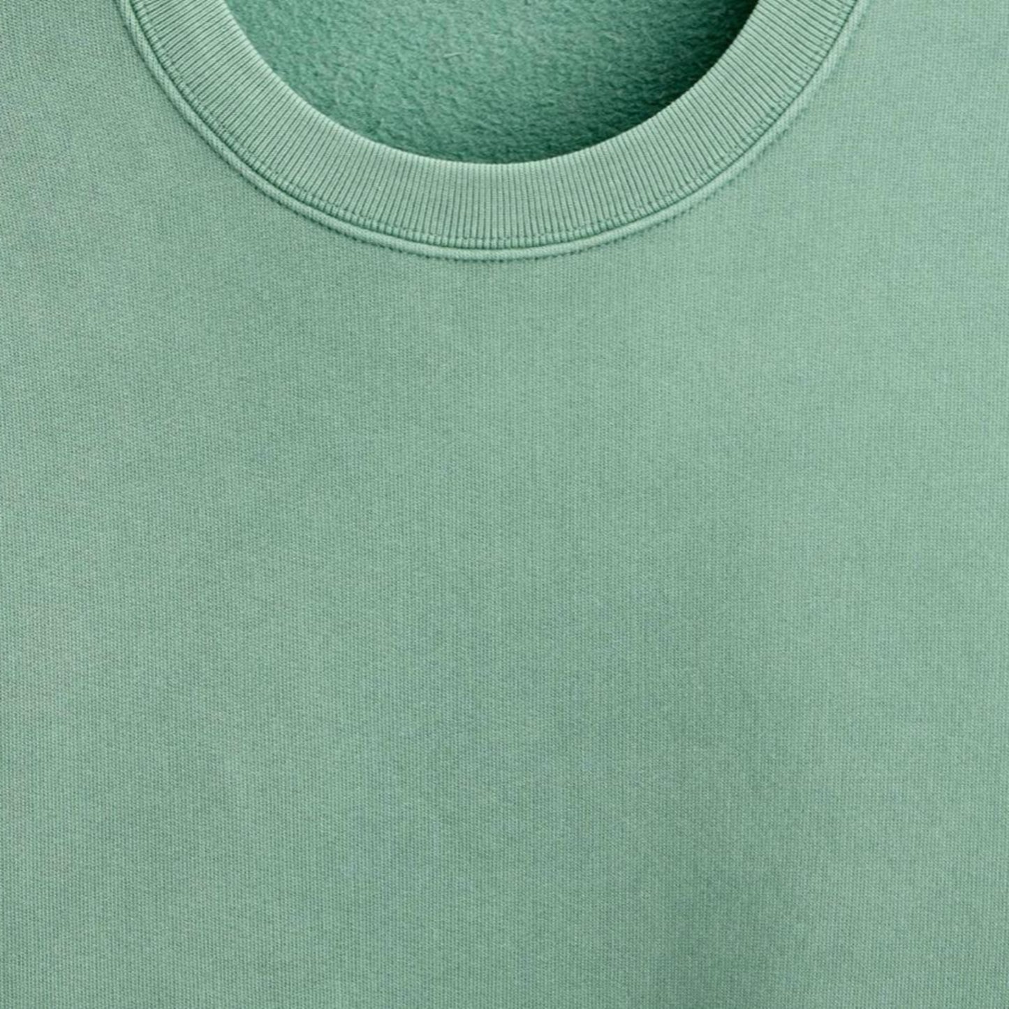 Close-up of a green sweatshirt with a focus on the neckline.