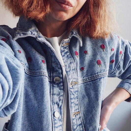 Person wearing a blue denim jacket with watermelon ice cream popsicle embroidery