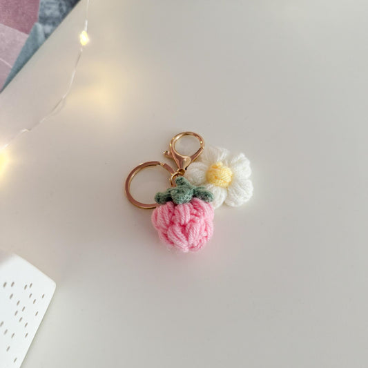 Keychain with pink strawberry design on a light surface