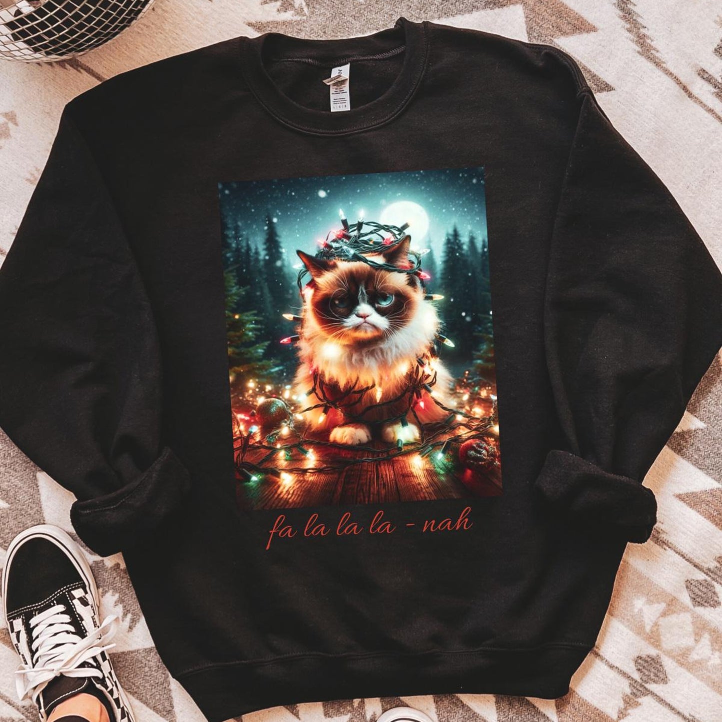 Black sweatshirt with a festive cat design on a patterned floor.