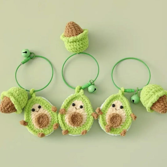 Set of green crochet avocado-shaped keychains with brown centers on a light green background