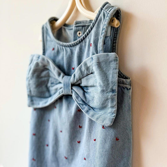 Light blue denim dress with a large bow on a beige background