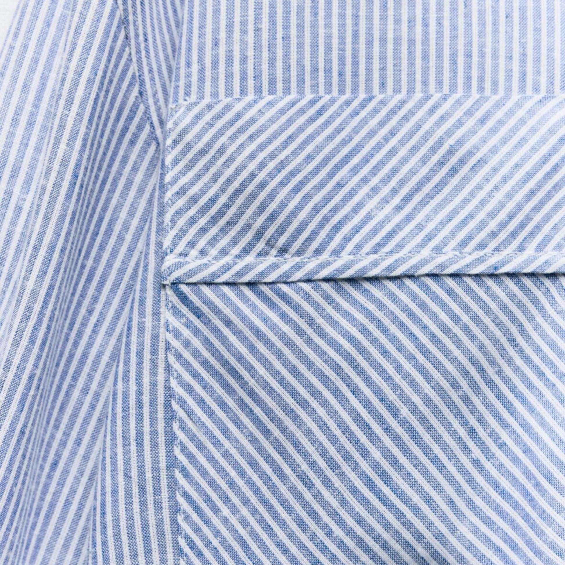 Close-up of a blue and white striped fabric with a pocket detail