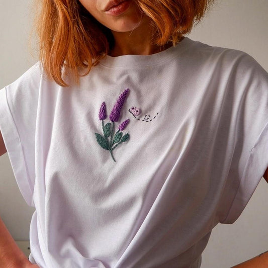 White t-shirt with purple floral embroidery worn by a person