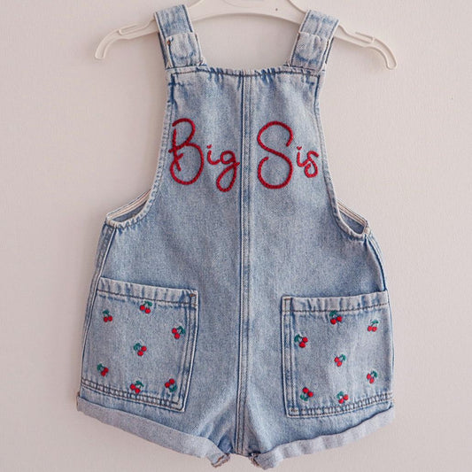 Denim overall shorts with 'Big Sis' text on a white background