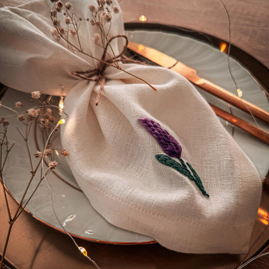 Decorative linen bag with embroidered lavender on a plate with cutlery