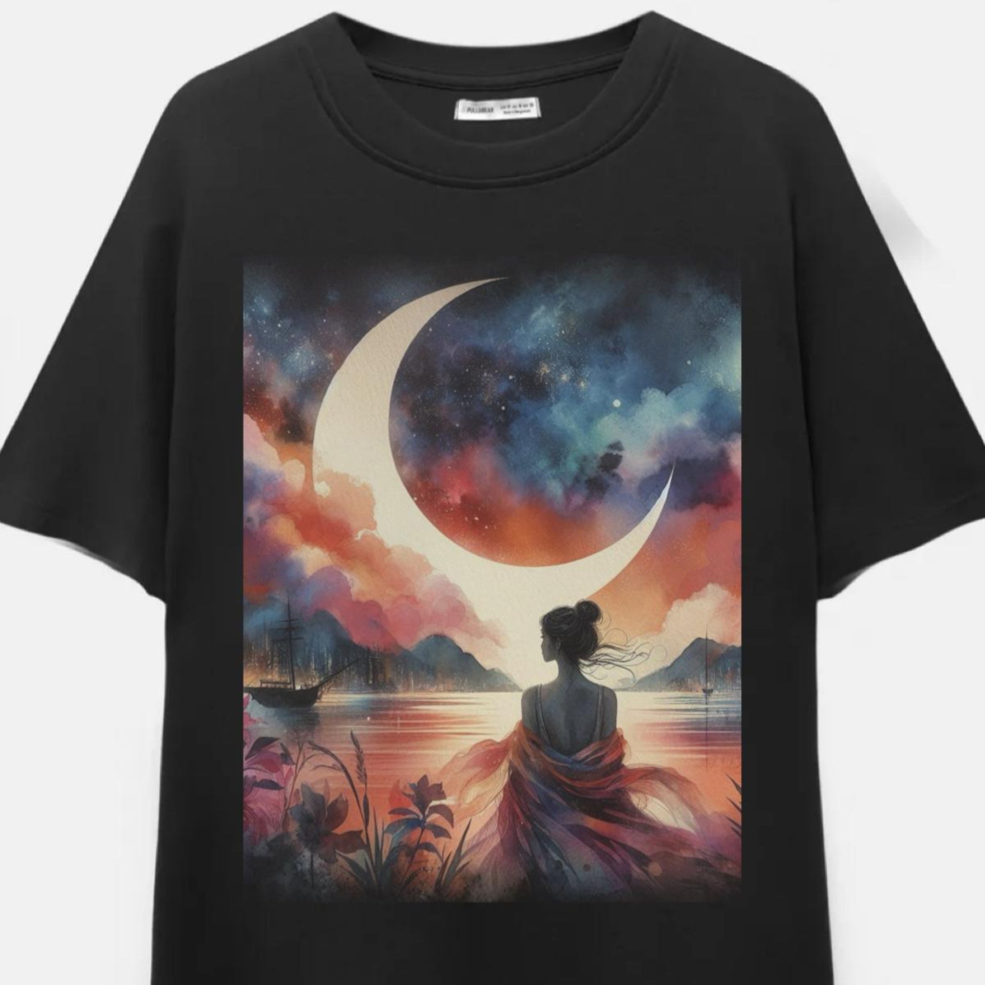 Black t-shirt with a colorful graphic of a woman sitting by a lake with a crescent moon and mountains.