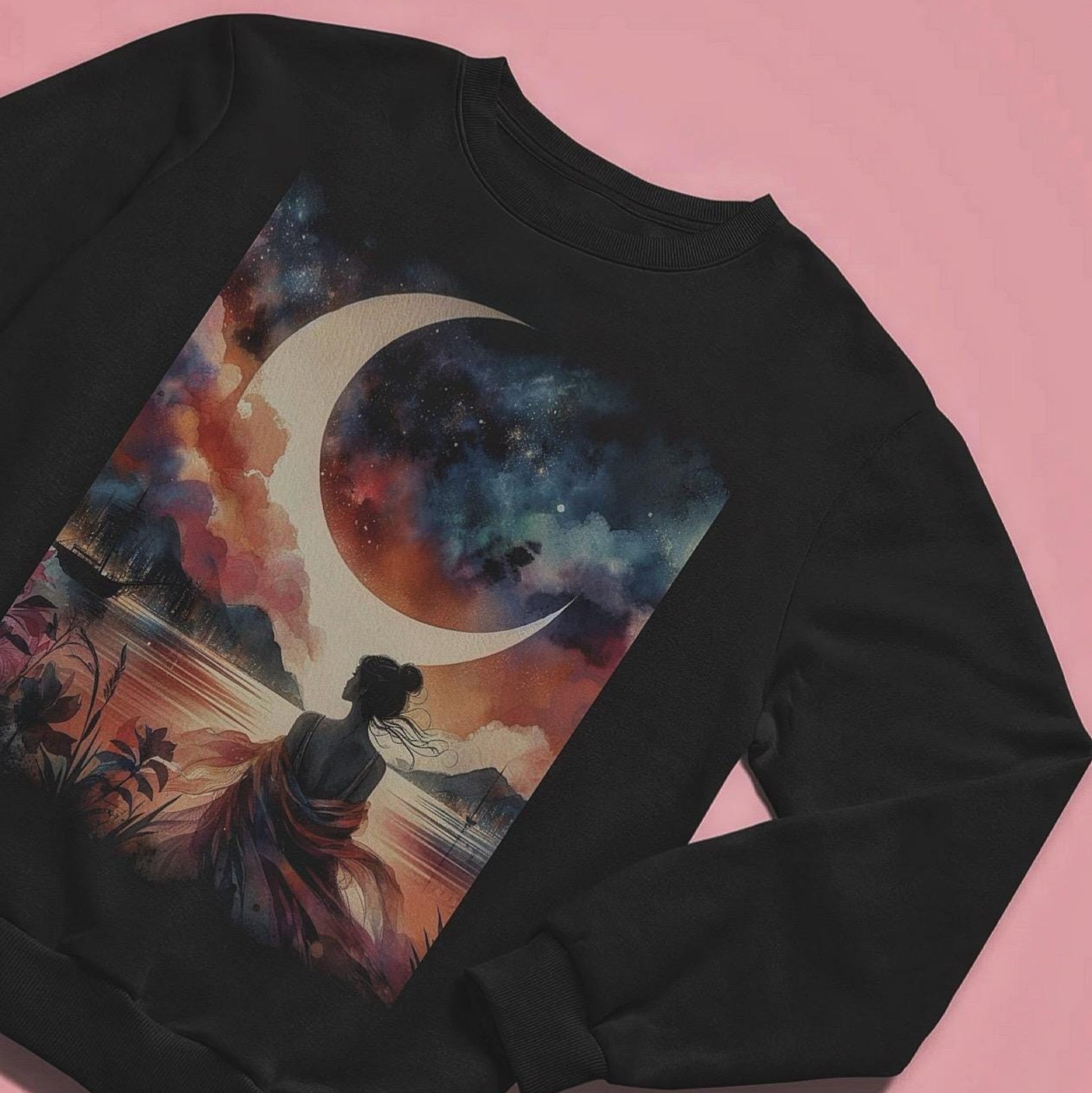Black sweatshirt with a colorful design of a woman, crescent moon, and landscape on a pink background